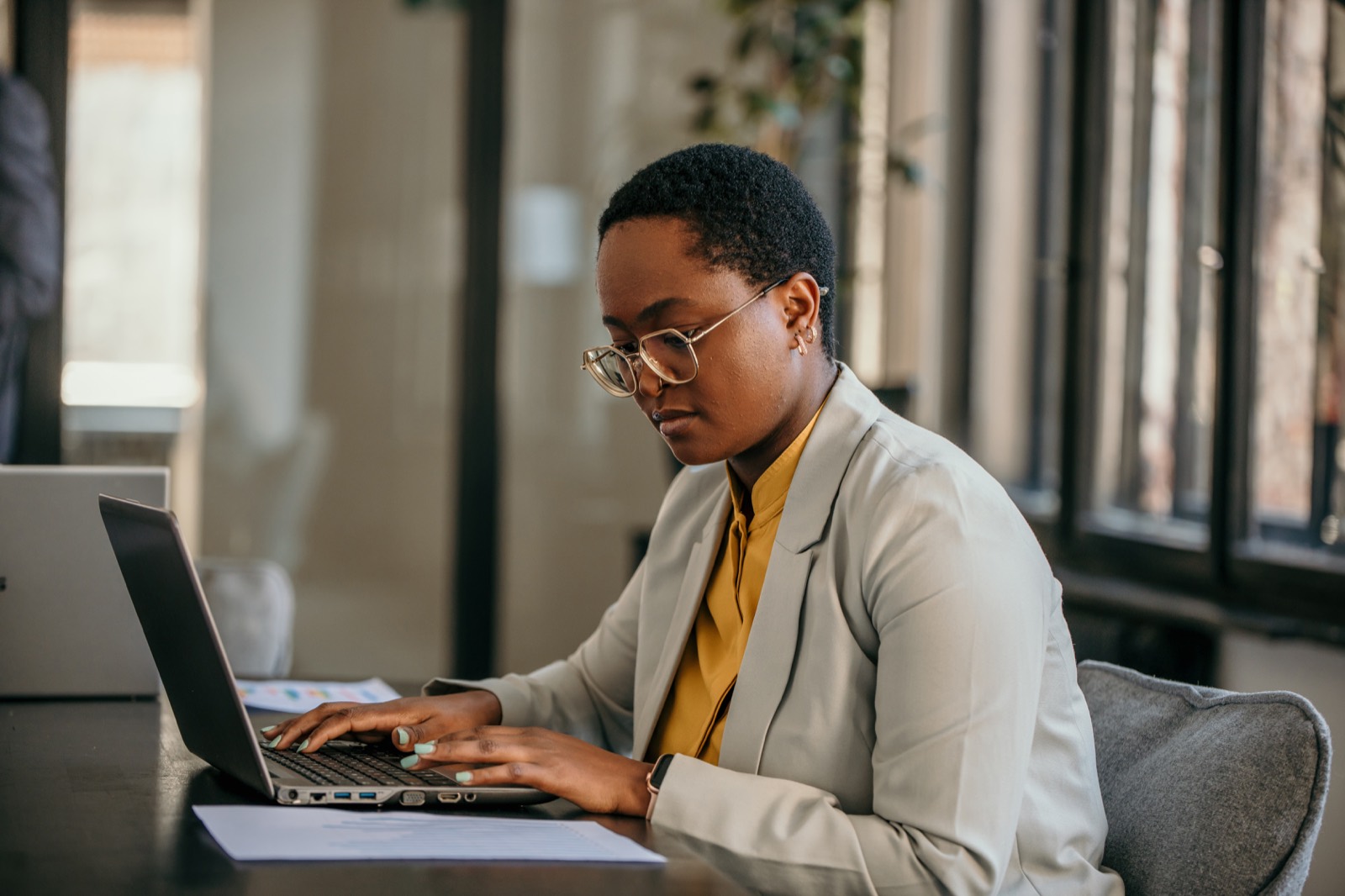 A manager working intently on a laptop in a modern office
