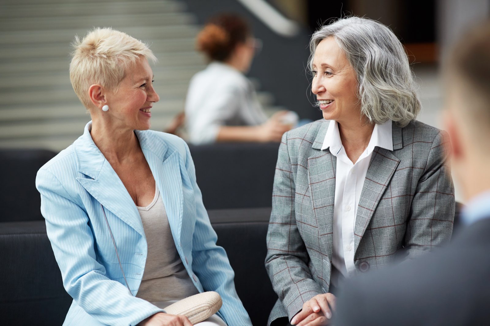 Two colleagues in conversation across a table in an office