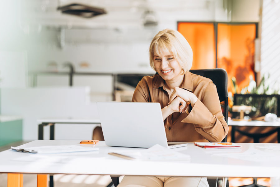 An HR leader at her desk, reading the reporting on how her managers are tracking