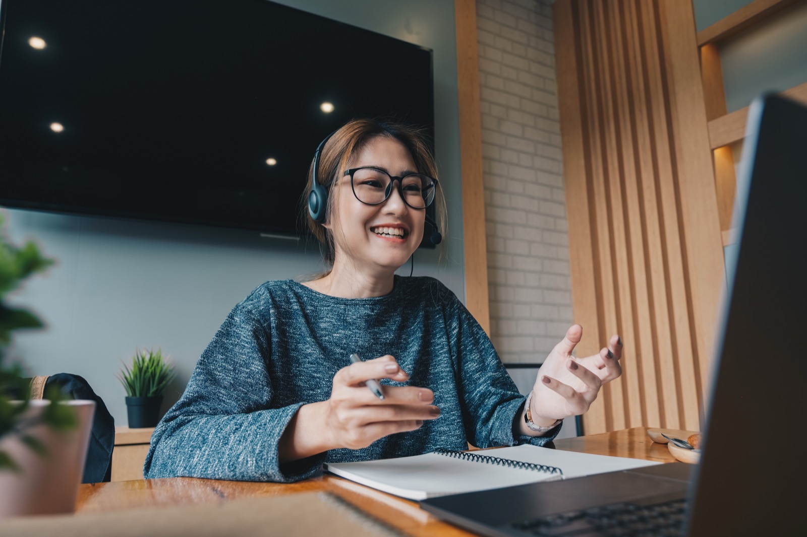 A manager smiling during a video coaching call while wearing a headset
